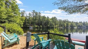 A deck with chairs overlooking a lake, surrounded by trees. - Nanas Nest - Lakefront Studio on Lovell Lake (Wakefield)