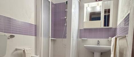 A bathroom with a toilet, bidet, and shower stall.