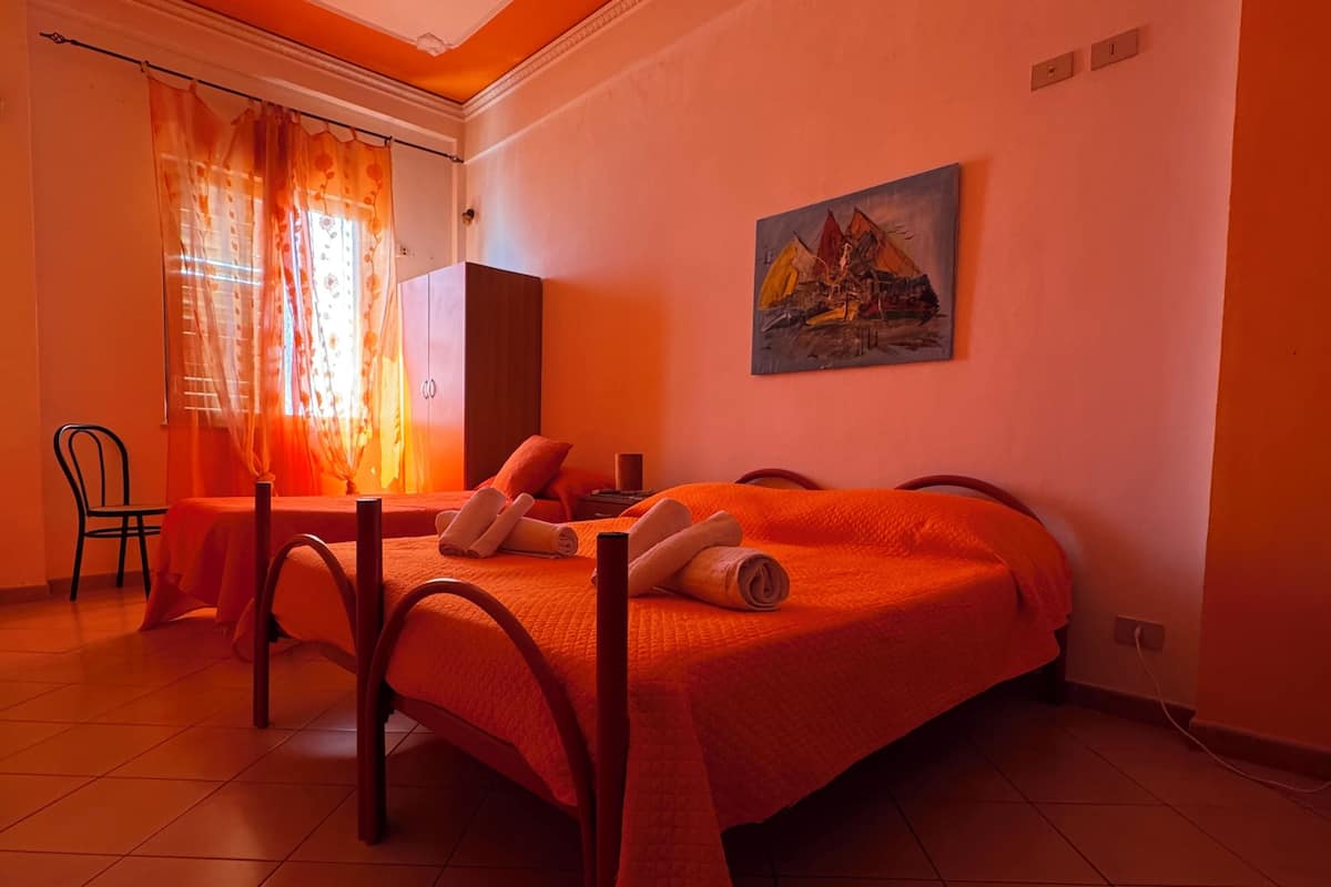 Una habitación con dos camas, un escritorio y una silla.
