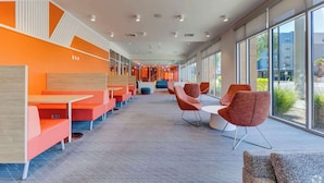 A modern indoor space with orange seating, large windows, and a view of the outside. - Boulevard Stays Modern Tempe 1BR ASU Pool, Gym 08 (Tempe)