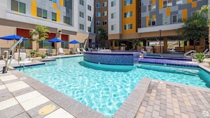 A hotel pool area with multiple levels of balconies, lounge chairs, and umbrellas. - Boulevard Stays Modern Tempe 1BR ASU Pool, Gym 08 (Tempe)