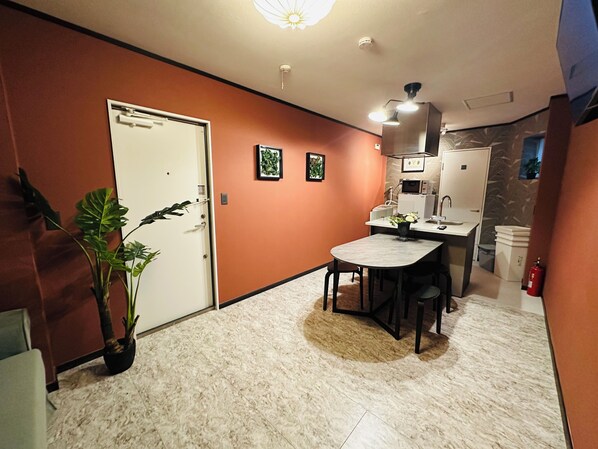 A compact kitchen with a dining area, a white door, and a potted plant. - A1 NewOpen Villa near Sky Tree, private house, large living room, 3 bedrooms, 2 bathrooms, 3 toilets, very comfortable space (墨田区)