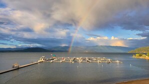 A marina with boats docked, a small structure on the dock, and mountains in the background. - Fresh Design, King & Queen - Seasons at Sandpoint (Sandpoint)