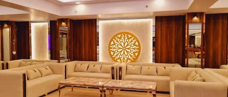 A spacious living room with a sectional sofa, a coffee table, and a decorative wall piece.