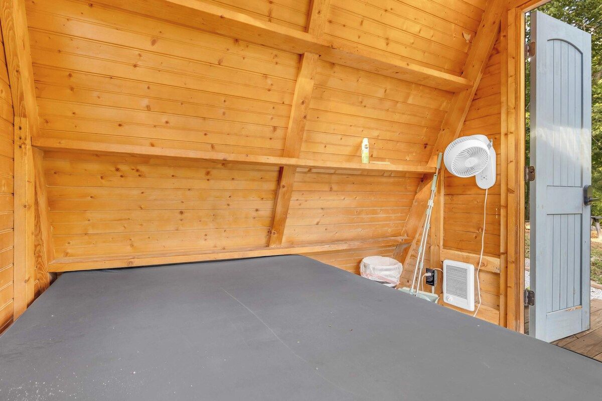 A wooden room with a fan, a door, and a small window.