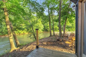 A wooden deck with chairs overlooking a river, surrounded by trees. - The Jessamine - Riverview Camping Pod, Close to DT (Easley)