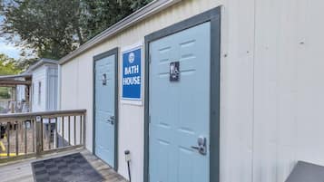 A row of light blue doors with a sign above them reading 'BATH HOUSE'.
