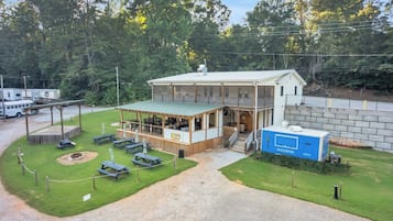 En lille, etetages bygning med en overdækket terrasse og picnicborde.
