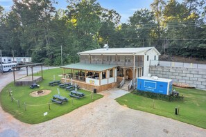 A small, single-story building with a covered patio area and picnic tables. - The Jessamine - Riverview Camping Pod, Close to DT (Easley)