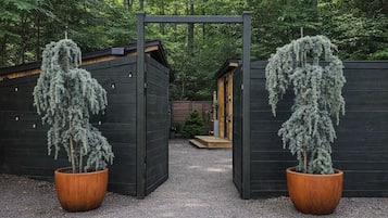 A wooden structure with a gravel path leading to a door, surrounded by trees.