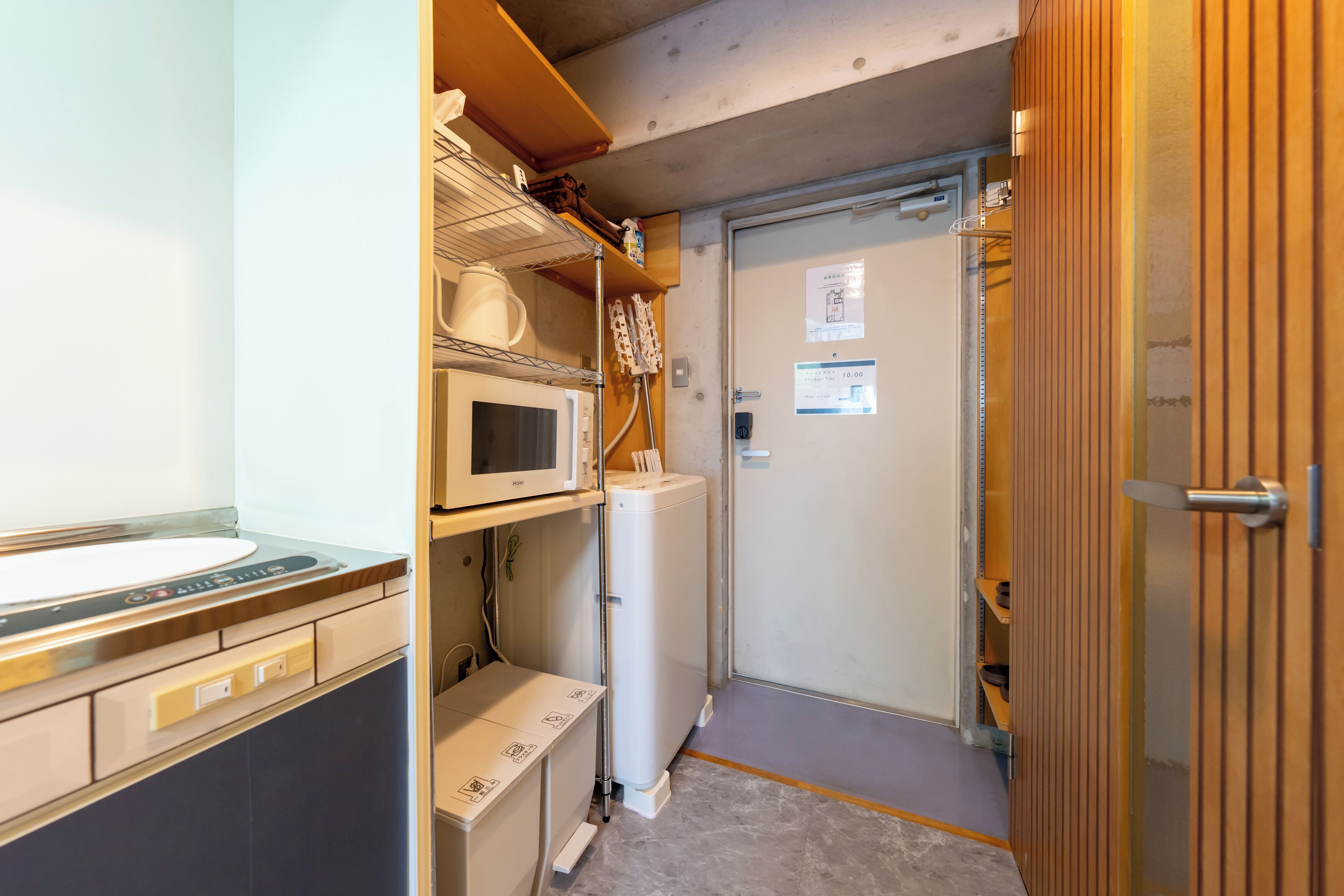 A compact bathroom with a microwave, a water heater, and a sink.