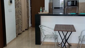 Eine moderne Küche mit Kochinsel, Edelstahlgeräten und einem Essbereich mit Tisch und Stühlen.