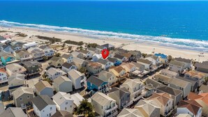 A coastal residential area with houses, a beach, and a red location marker. - Ocean Lakes 920 | Ocean View + 4 King Beds | Sleeps 13 (Myrtle Beach)