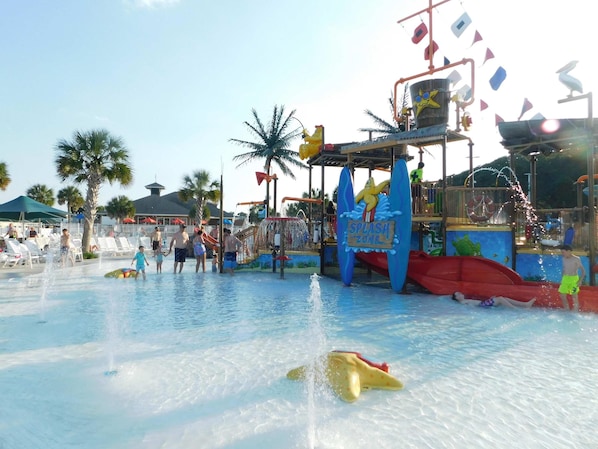 Parque acuático con zona de chapuzones, toboganes y una piscina.