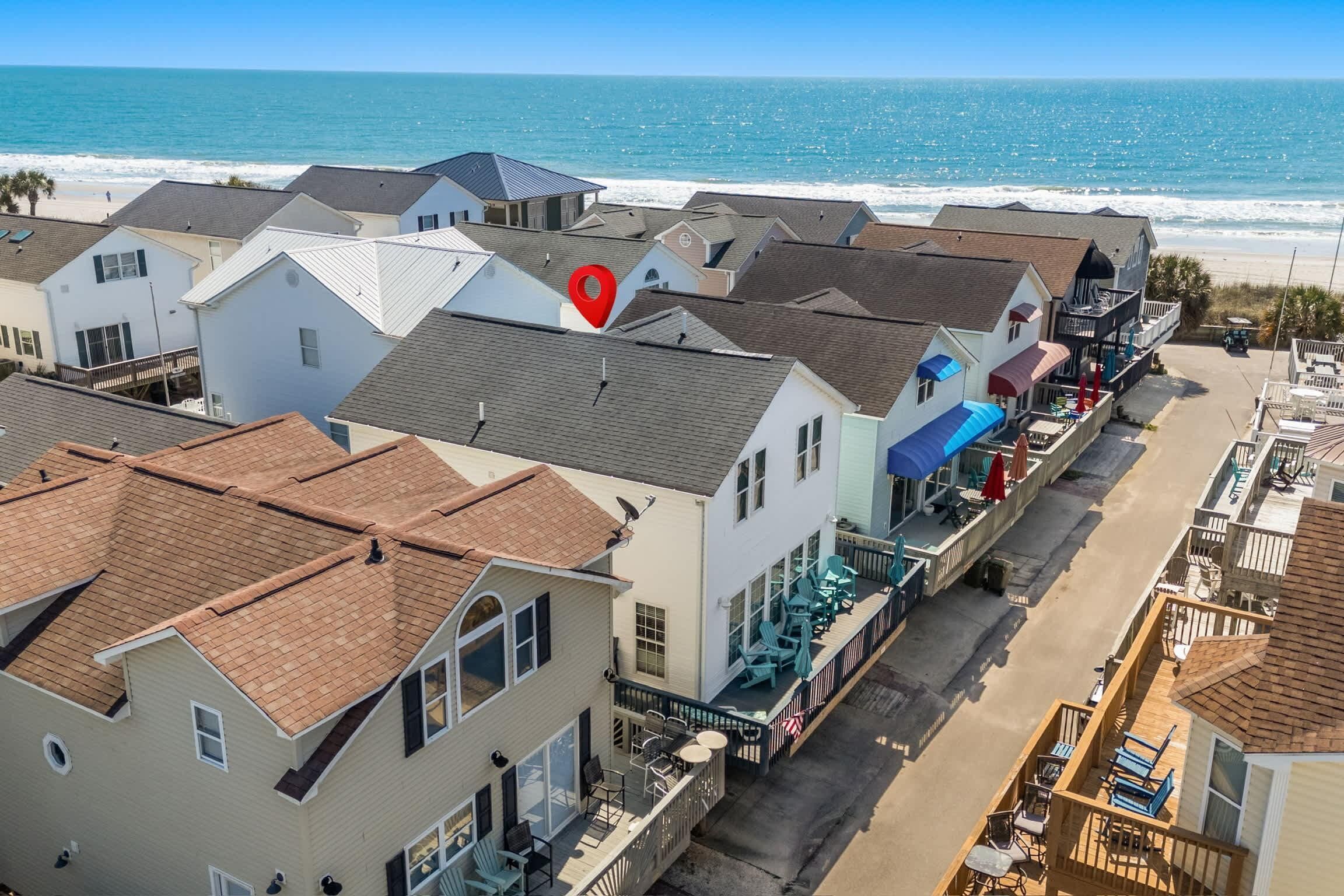 A coastal hotel with multiple buildings, a beach view, and outdoor seating areas.