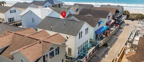 A coastal hotel with multiple buildings, a beach view, and outdoor seating areas.