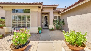 A house with a tiled roof, a front door with a decorative design, and potted plants in the front yard. - Extended-stay Oasis: Gilbert Getaway w/ Office! (Gilbert)
