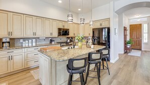 A modern kitchen with granite countertops, stainless steel appliances, and a central island with bar stools. - Extended-stay Oasis: Gilbert Getaway w/ Office! (Gilbert)
