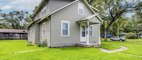 A two-story house with a front porch and a well-maintained lawn.