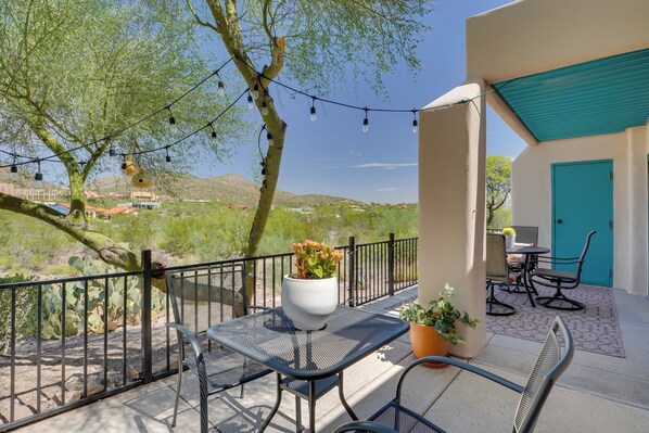 An outdoor patio with a table and chairs, a potted plant, and a view of the surrounding landscape. - Amazing Desert Views! Tucson Casita on Golf Course (Tucson)