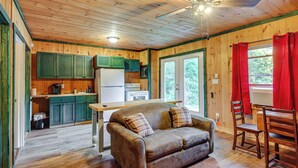 A wooden cabin interior with a kitchen, a sofa, and a dining area. - 10 Mi to Gore Mountain! Pet-friendly Cabin (North River)