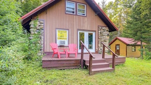 A cabin with a stone exterior, a wooden deck, and a red door. - 10 Mi to Gore Mountain! Pet-friendly Cabin (North River)