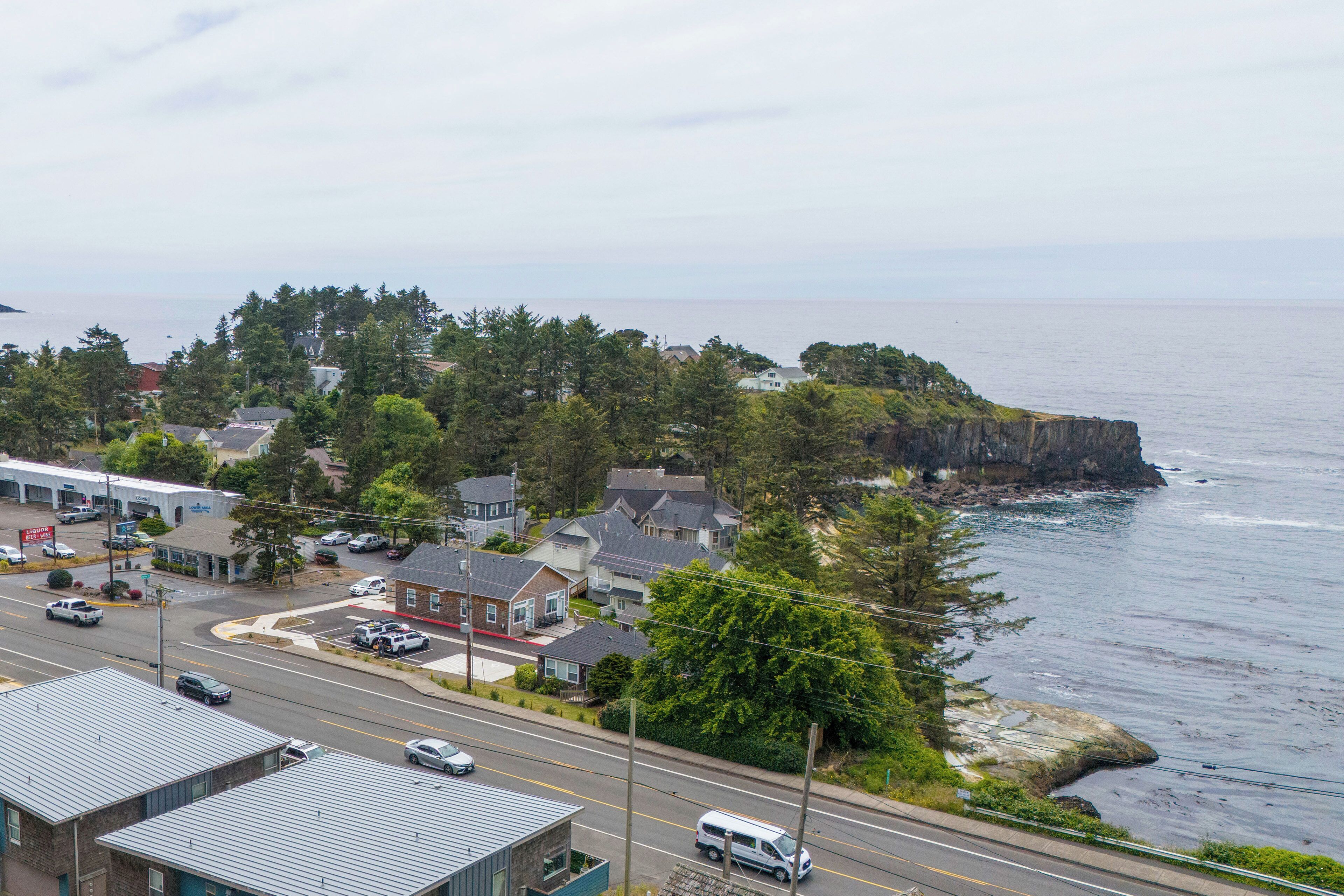 A coastal town with houses, a road, and a cliff overlooking the sea.