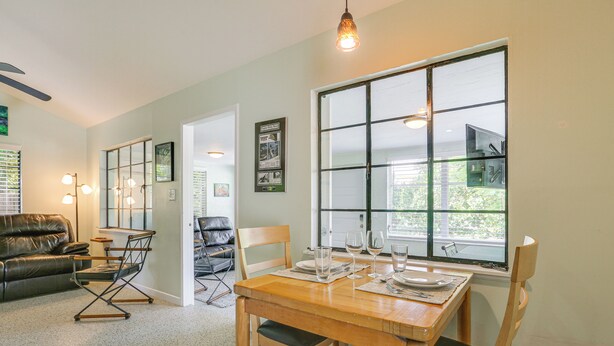 A dining area with a wooden table, chairs, and a large window.