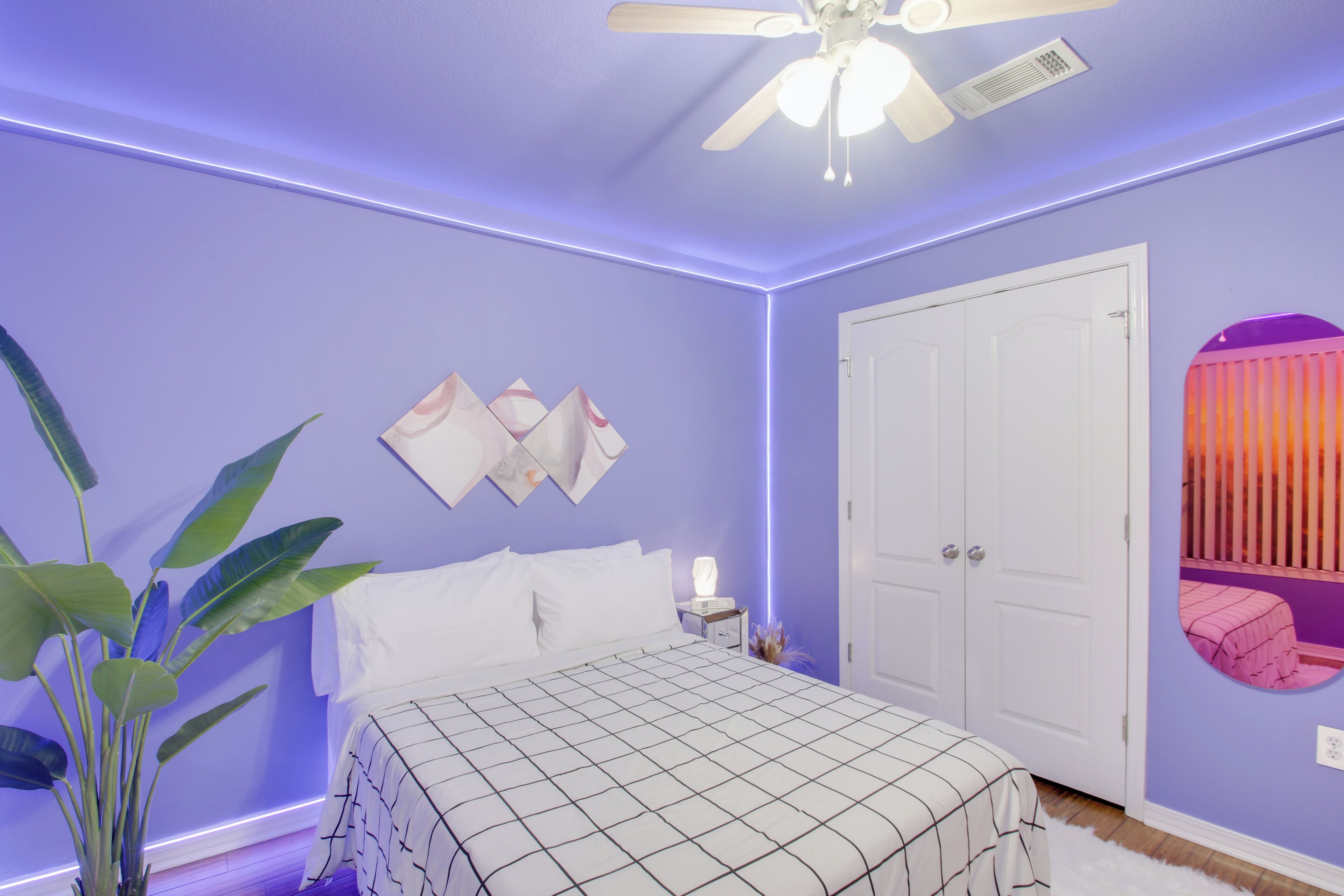A bedroom with a bed, nightstand, and ceiling fan.