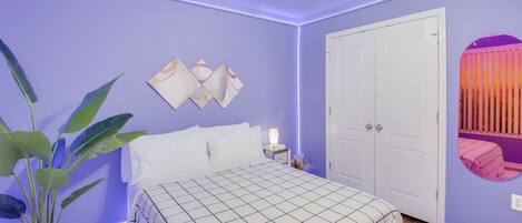 A bedroom with a bed, nightstand, and ceiling fan.