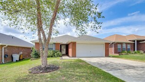 A residential house with a garage, brick exterior, and a lawn with a tree. - 3 Mi to Escambia Bay: Home w/ Deck & Private Yard! (Milton)