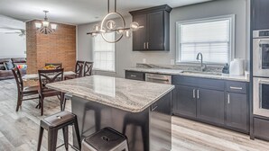 A modern kitchen with dark cabinetry, a granite countertop, and stainless steel appliances. - 4 Mi to Loris Nature Park: Family Home w/ Yard (Loris)