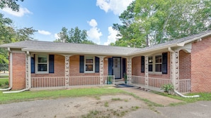A two-story brick house with a covered porch, a front door, and a small front yard. - Walk to Dtwn & Freed-hardeman: Home w/ Fenced Yard (Henderson)