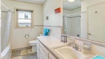 A bathroom with a bathtub, toilet, and sink.