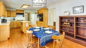 A dining area with a blue tablecloth, wooden chairs, and a chandelier. - Walk to Dtwn & Freed-hardeman: Home w/ Fenced Yard (Henderson)
