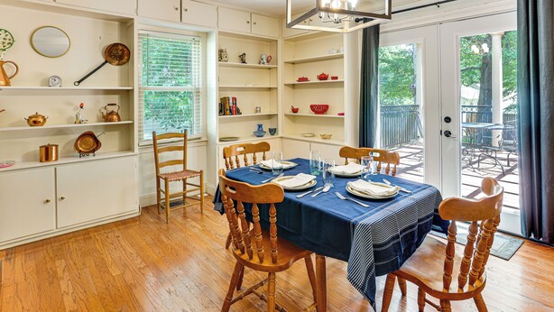 A dining room with a table set for four, wooden chairs, and a blue tablecloth. - Walk to Dtwn & Freed-hardeman: Home w/ Fenced Yard (Henderson)