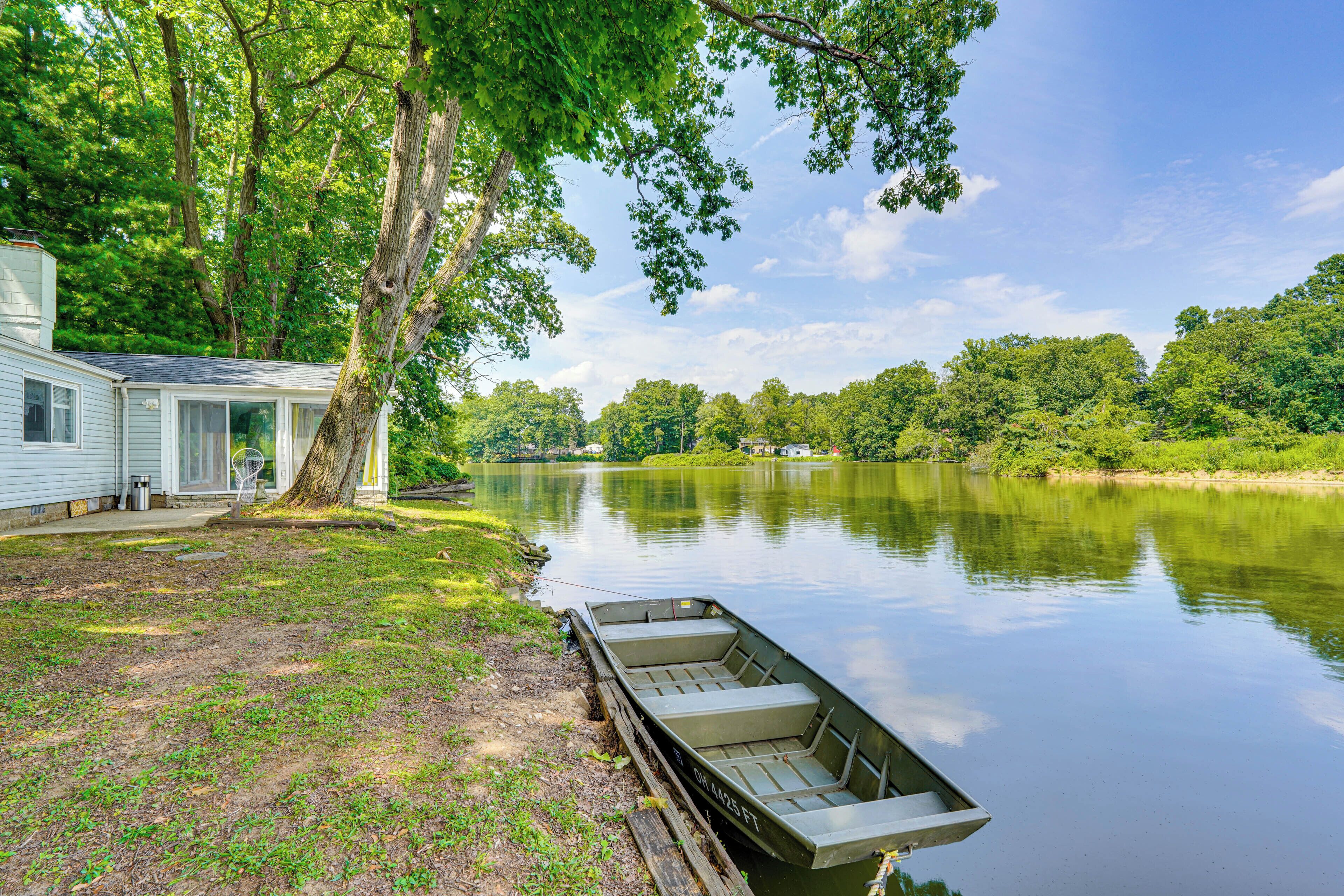 A lakeside cabin with a dock and a boat.