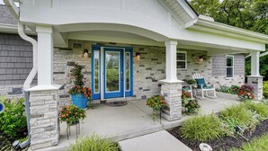 A house with a stone facade, a blue door, and a covered porch with chairs. - 4 Mi to Dtwn: Ohio River Valley Home w/ Deck! (Aurora)