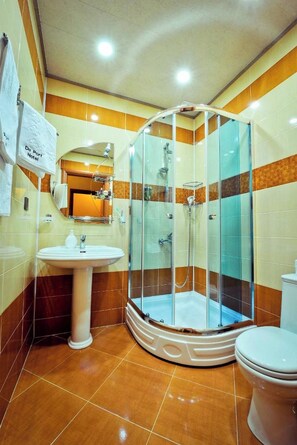A modern bathroom with a glass-enclosed shower, a pedestal sink, and a toilet. - Du Port Boutique Hotel (Baku)