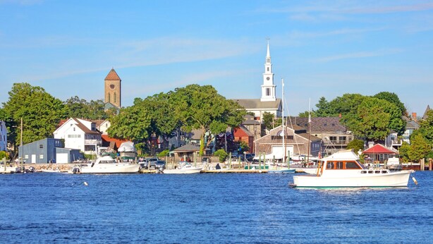 A waterfront town with a prominent church tower, a white steeple, and a dock with boats. - Seaside Stay in Historic Warren (Warren)