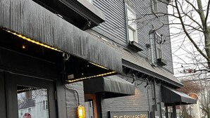 A building with a sign reading "THE SQUARE PEG" and outdoor seating. - Seaside Stay in Historic Warren (Warren)