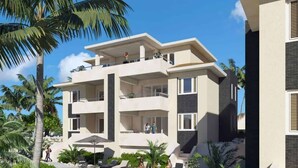 A modern multi-story hotel with a pool area surrounded by lush greenery and palm trees. - Caribbean Lounge — Elegant Island Apartment (Blue Bay Golf & Beach Resort)
