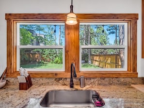 A kitchen with a large window, a sink, and a wooden countertop. - Tahoe Cabin One Block from Lakeside Beach-Heavenly (South Lake Tahoe)