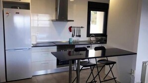 A modern kitchen with a built-in refrigerator, a stove, and a window above the sink. - Wonderful views, perfect for couples and families, pets welcome. (El Espinar)