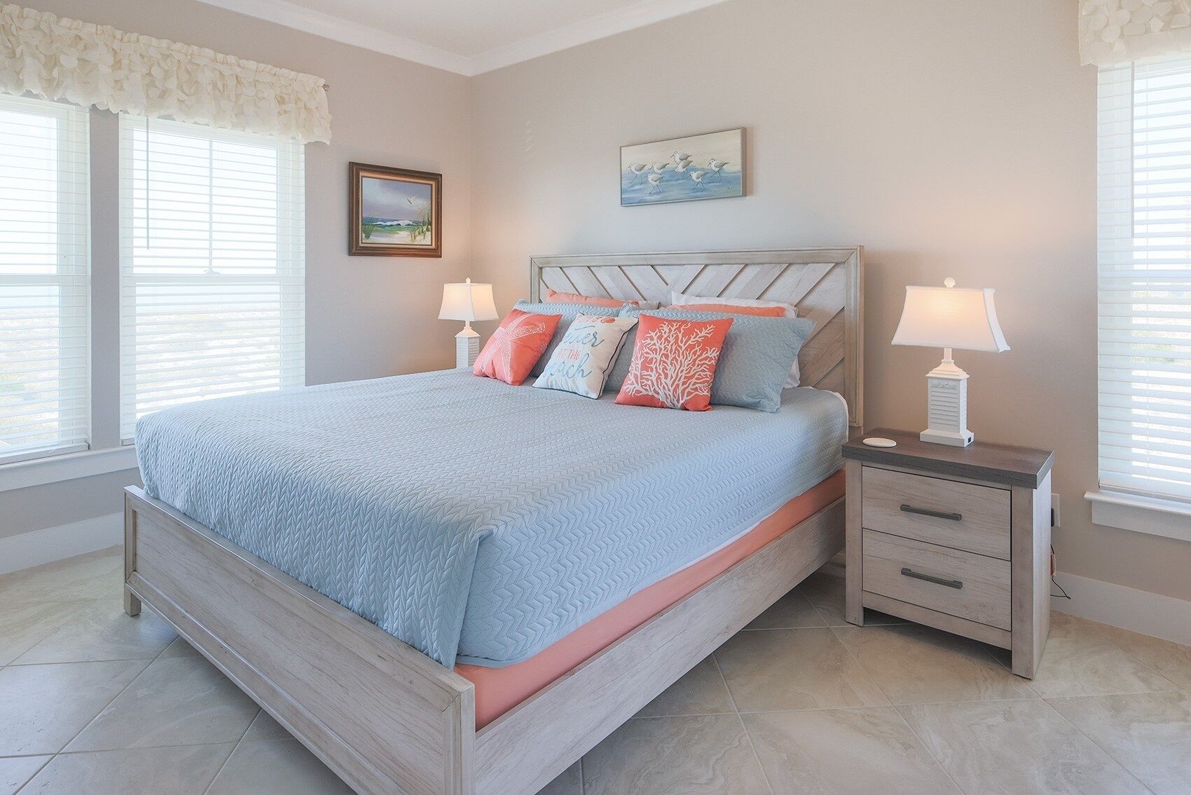A bedroom with a bed, nightstands, and a window with blinds.