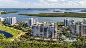 A high-rise hotel with multiple floors, surrounded by water bodies and greenery. - Waterside #835: Bayscape Bliss 3br/2ba Condo W/ Pool! 3 Bedroom Condo (Fort Myers Beach)
