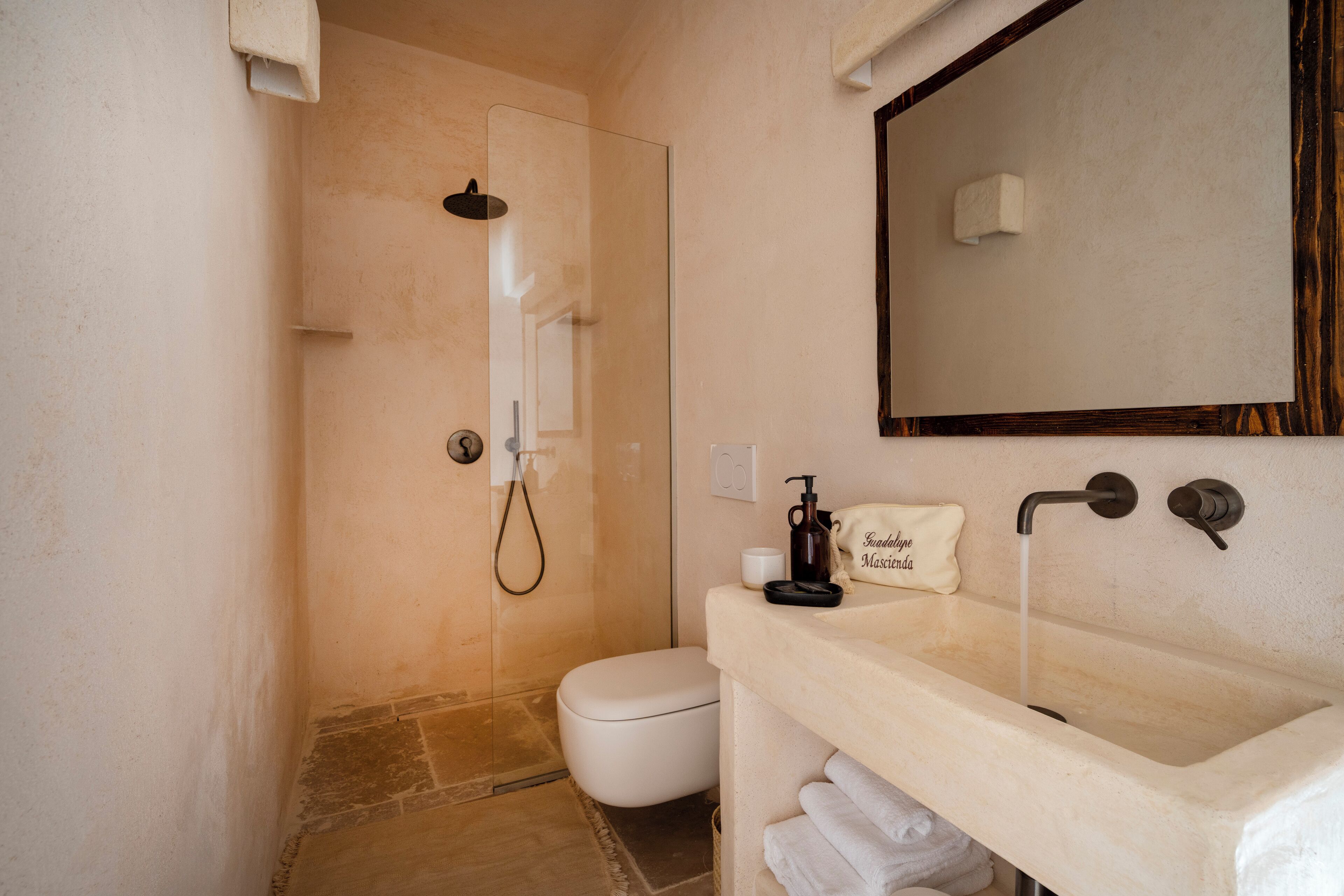 A bathroom with a shower, toilet, and sink.
