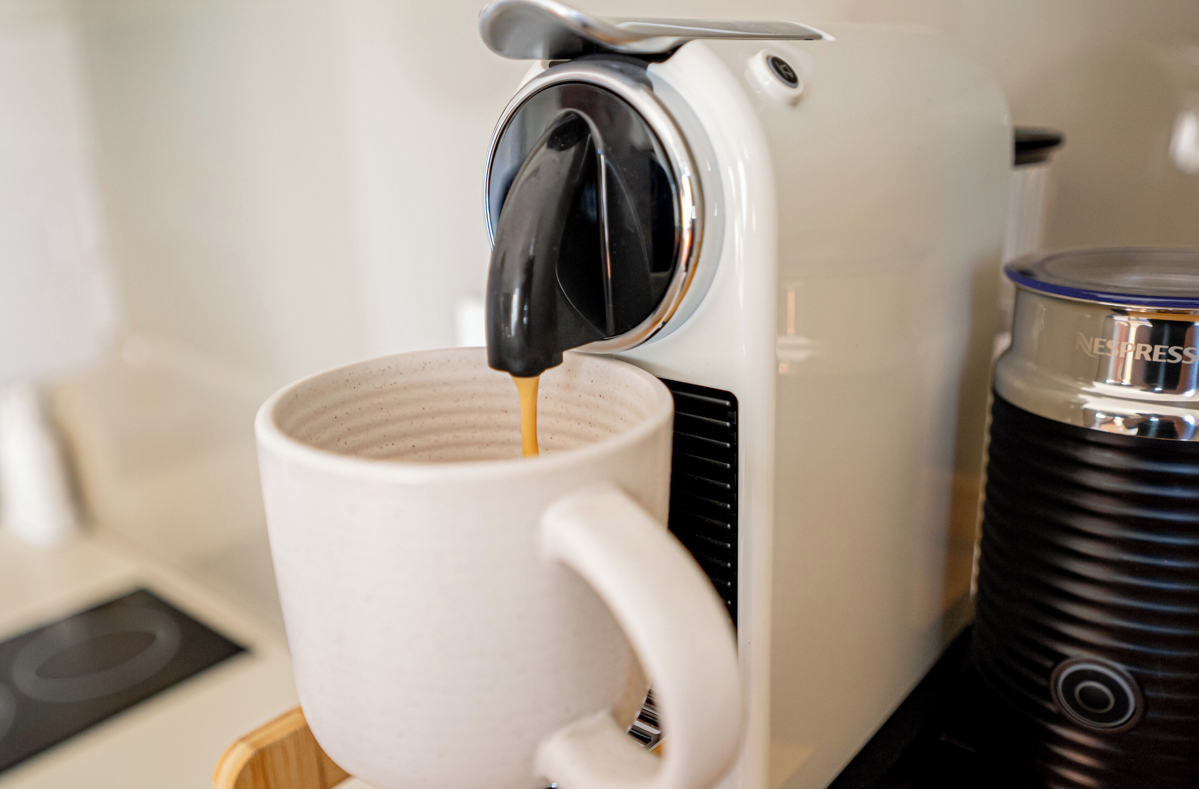 Een koffieapparaat schenkt koffie in een witte mok.