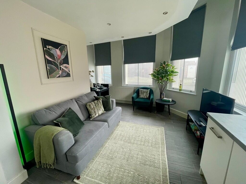 A relaxing open-plan living space with a Smart TV offering Netflix and a comfortable sofa bed. The layout includes a small dining nook and a combined kitchen and lounge area, creating a practical and inviting place to unwind.
