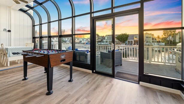 A spacious room with a foosball table, large windows, and a deck with outdoor furniture. - 25%Off30+ Stay! Channel Islands Harbor Great Views (Oxnard)